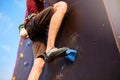 Bottom close up view of rock climber foot on training artificial climbing wall outdoors. Man feet in climbing shoes on Royalty Free Stock Photo