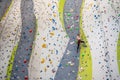 Rock climber young woman hanging on colored hooks on climbing artificial wall indoors of sport centre of Prague. Extreme Royalty Free Stock Photo