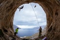 Rock climbers in cave: belayers watching leading climbers Royalty Free Stock Photo