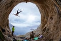 Rock climbers in cave: leading climber swinging on rope after falling of cliff