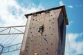 Rock climbing on an artificial rise. The boy climbs on the wall in an extreme park Royalty Free Stock Photo