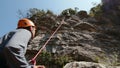 Rock climbing enthusiast managing the belay system during a steep ascent, immersed in the art of mountaineering.