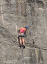 Rock Climbing Girl on rock face in red top.