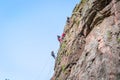 Rock climbing. A group of young rock climbers climb the vertical granite rock. Extreme sport.