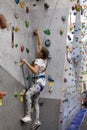 Rock climbing in indoor gym, girl has mountaineering exercises Royalty Free Stock Photo