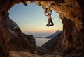 Rock climbing at sunset. Young man climbing route in cave, female partner belaying him