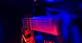 Rock Concert. Guitarist Plays The Guitar. The Guitar Illuminated With Bright Neon Lights. Focus On Strings.