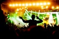 Rock concert, silhouettes of happy people raising up hands