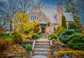 Rock cottage with lush landscaping and steps down to street in early spring Royalty Free Stock Photo