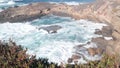 Rock crag of cliff, ocean beach, Point Lobos, California coast. Waves crashing.