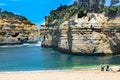 Couple in wonder of rock formations in bay Twelve Apostles, Australia, morning light at rock formation