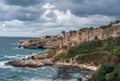 Rock Formations coast Against Sky. seascape with gloomy cloudy sky, rocky shore, waves on sea