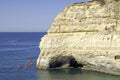 Rock formations and people doing kayaks in the Atlantic ocean to visit the Benagil caves, Algarve, Portugal