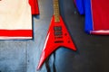 A red rock guitar hangs on a dark wall. Royalty Free Stock Photo