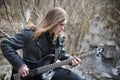 Rock guitarist on the steps. A musician with a bass guitar in a Royalty Free Stock Photo