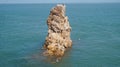 Rock jutting from sea with a seagull perched on it