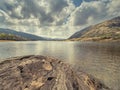 Rock, lake and mountain and dramatic sky. Beautiful nature scenery in county Kerry, Ireland. Irish stunning nature scene landscape Royalty Free Stock Photo