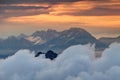 Rock massif of Kamnik Savinja Alps rise above clouds at sunrise Royalty Free Stock Photo