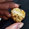 Rock mineral raw gold fingers holding rock