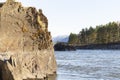 rock in mountain river on snowy mountains background. Atmospheric landscape, selective focus Royalty Free Stock Photo