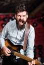 Rock music concept. Musician with beard play electric guitar. Talented musician, soloist, singer play guitar in music Royalty Free Stock Photo