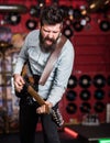 Rock music concept. Talented musician, soloist, singer play guitar in music club on background. Musician with beard play Royalty Free Stock Photo