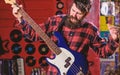 Rock musician concept. Musician, frontman, soloist, singer play guitar in music club on background. Man on shouting face Royalty Free Stock Photo