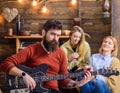 Rock musician with long beard and tattooed arm playing guitar. Bearded man with stern eyes looking at camera. Guitarist Royalty Free Stock Photo