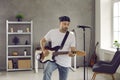 Rock musician standing in rehearsal room and playing music on his electric guitar Royalty Free Stock Photo