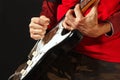 Rock musician put fingers for chords on electric guitar on black background