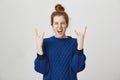 Rock n roll lives in us. Portrait of excited and thrilled young european redhead girl screaming from positive emotions