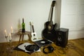 Rock'n'roll setup with ukulele, acoustic guitar, speaker, candle Royalty Free Stock Photo