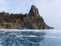 A rock in the Peschanaya Bay and crystal ice of lake Baikal in winter Royalty Free Stock Photo