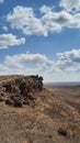 A rock and a plain with blue sky