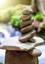 Rock pyramid, rock balancing art. Close-up of a stack of stones in perfect balance in a mountain forest. Sun rays. Royalty Free Stock Photo
