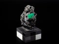 Rock with raw emerald crystal with black background