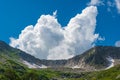 Rock ridge with snow and stone placers under blue sky. Summer trip to mountain valley Royalty Free Stock Photo