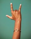 Rock and roll hand sign by a studio for party, cool or wild greeting with rings and bracelet jewelry. Emoji, punk and