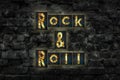 Rock and Roll. Words made from rusty iron letters, on old vintage bricks wall. Direction in music. Musical style. Design