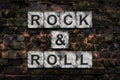 Rock and Roll. Words on stone blocks, on old vintage bricks wall. Direction in music. Musical style. Design