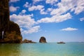 The rock in the sea is painted with gold paint. Speedboat floats nearby. Blue sky, a lot of clouds. Cave beach. Pranang, Krabi