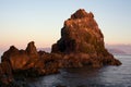 Rock in the sea in the red light of low sun.