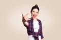 Rock sign. Happy funny toothy smiley young woman showing Rock sign with fingers. studio shot on beige background. Royalty Free Stock Photo