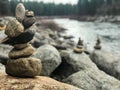 Rock stacks near river lined with pine trees