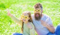 Rock star concept. Dad and daughter sits on grass at grassplot, green background. Family spend leisure outdoors. Child