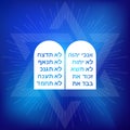 Rock of ten commandments with Hebrew alphabet on blue background