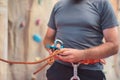 Rock wall climber wearing safety harness and climbing equipment indoor, close-up image