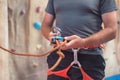 Rock wall climber wearing safety harness and climbing equipment indoor, close-up image Royalty Free Stock Photo