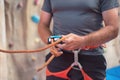 Rock wall climber wearing safety harness and climbing equipment indoor, close-up image