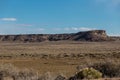 Rock wall lining back of open high desert in rural New Mexico